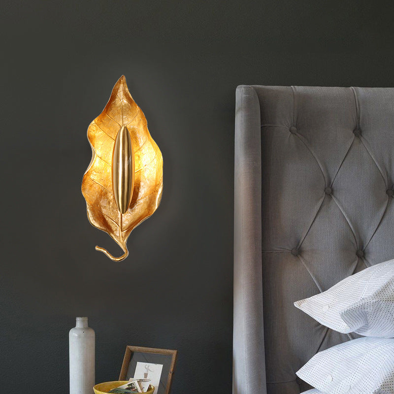 Golden leaf wall sconce in a bedroom